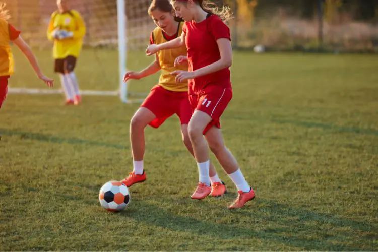 Female soccer players try to retain possession of the ball at team soccer training