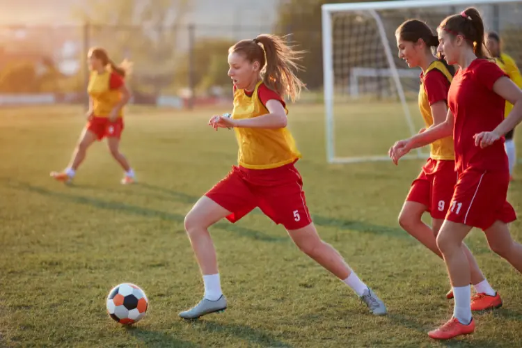 A female girls soccer player moves the ball away from pressure during a soccer training session