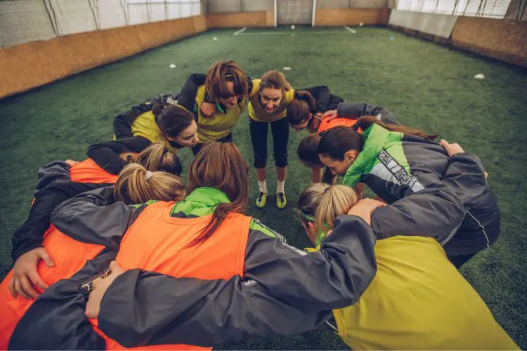An indoor soccer team huddles up for a team talk