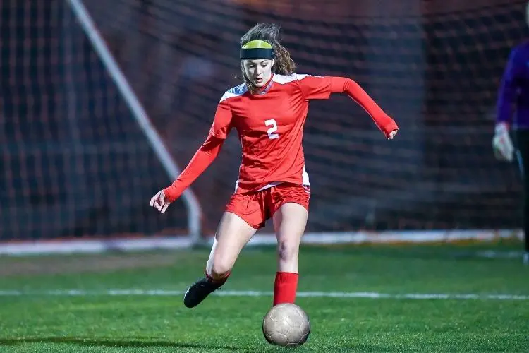 A soccer player prepares to pass the ball during a high school soccer game