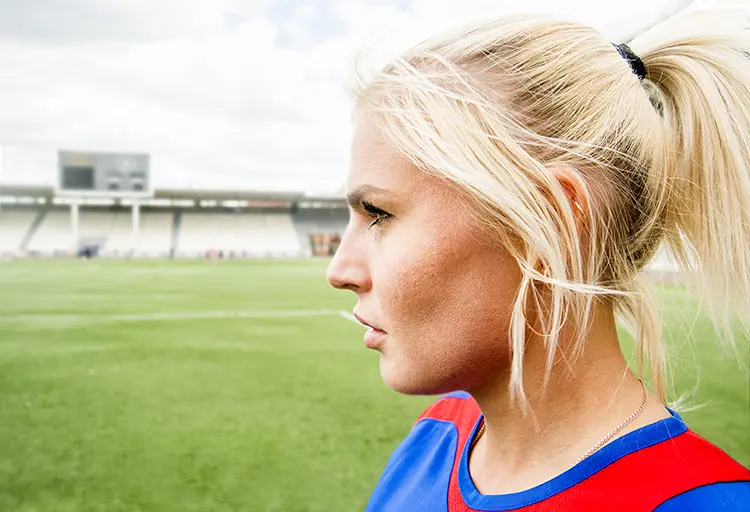 Side profile of a soccer player looking out over the soccer field