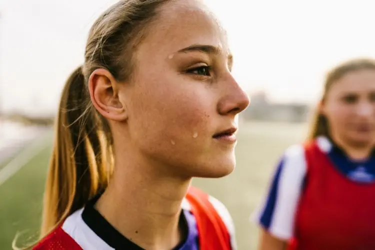 A close up portrait of a focused, attentive female soccer player